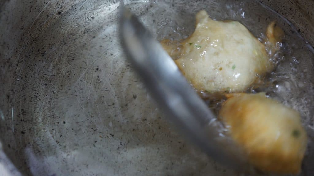 Use two tablespoons to drop batter mixture into preheated oil. This technique gives you control over the portion size of each accra.